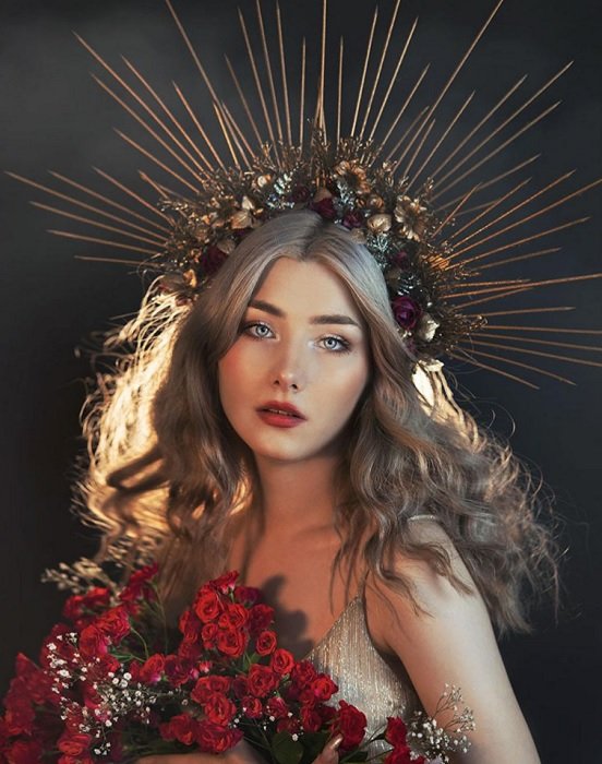 portrait of a woman with spiky crown holding flowers
